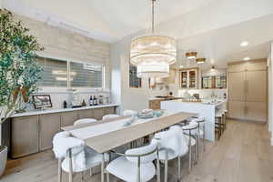 Dining area featuring lofted ceiling and light wood finished floors