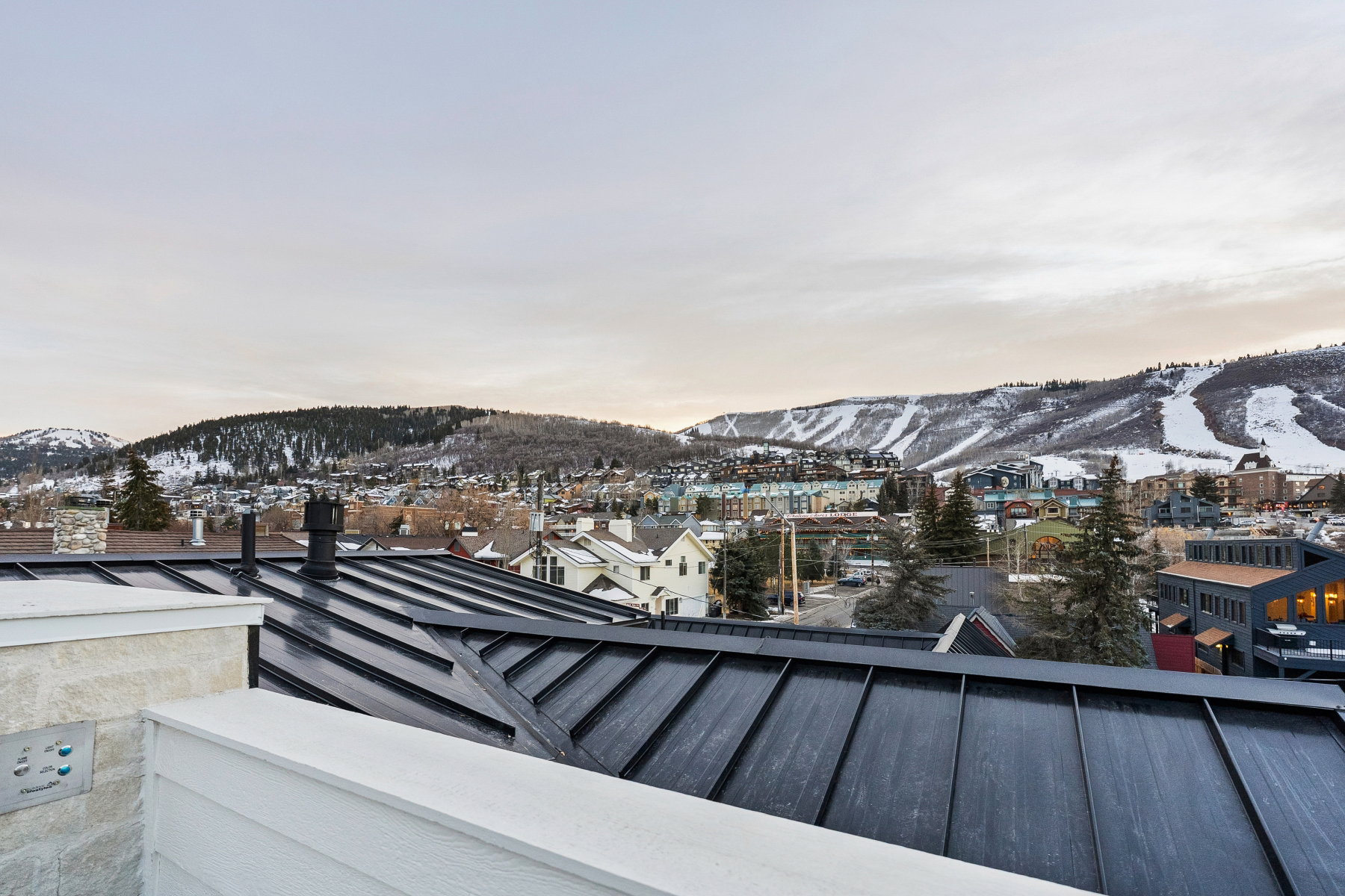 Snow covered back of property featuring a mountain view