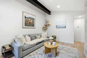 Living room featuring light wood finished floors, vaulted ceiling, and recessed lighting