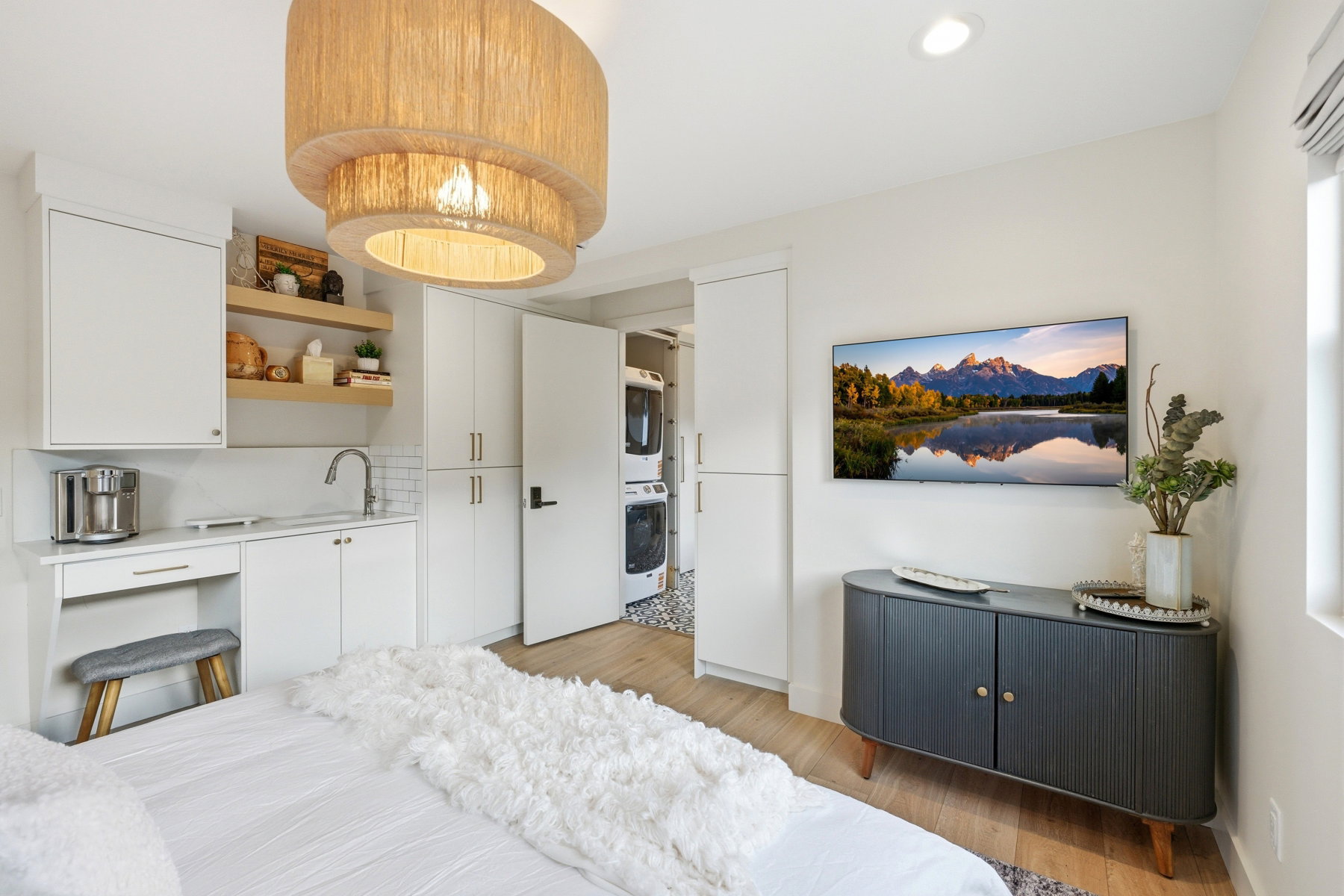 Bedroom with stacked washer / dryer, light wood finished floors, and recessed lighting