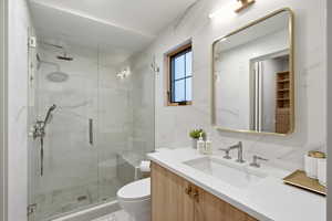 Full bathroom with vanity and a marble finish shower