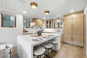 Kitchen featuring a center island, a kitchen bar, light wood-style flooring, recessed lighting, and light wood finish cabinetry