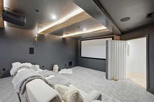 Carpeted cinema room with recessed lighting and beamed ceiling