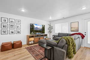 Living room with light wood-type flooring and a textured ceiling