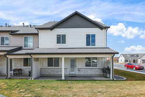 View of front facade featuring stone siding, a front yard, and a shingled roof