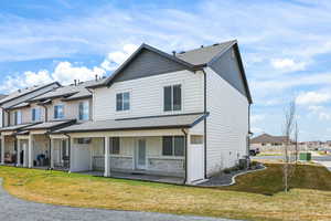 View of front of property featuring roof with shingles, a front yard, and stone siding