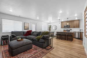 Living room with light wood-type flooring and a chandelier
