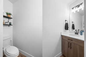 Half bath featuring vanity and wood finished floors