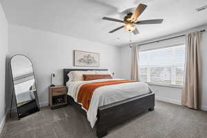 Bedroom featuring dark colored carpet and ceiling fan