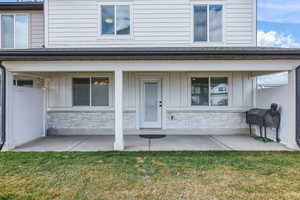 Entrance to property with stone siding, board and batten siding, and a yard