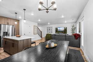 Dining area with light wood-style flooring and hanging lights