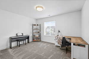 Office area featuring light carpet and baseboards