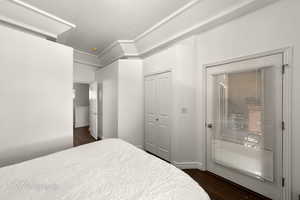 Bedroom with dark wood-type flooring and a closet