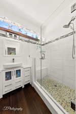Full bath featuring vanity, a stall shower, and dark wood-type flooring