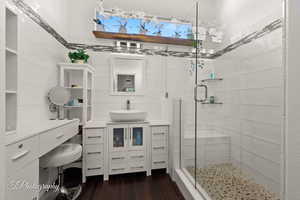 Bathroom with vanity, a stall shower, and dark wood-type flooring