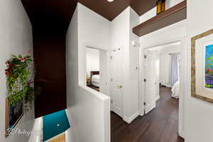 Corridor featuring dark wood-type flooring and baseboards