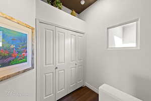 Corridor featuring dark wood-style flooring and a textured wall