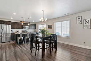 Dining room featuring hanging lights and dark wood-type flooring