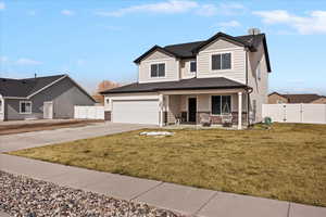 View of front facade with a porch, a gate, driveway, stone siding, and board and batten siding