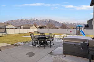 Fenced backyard with an outdoor dining area, a patio area, and a mountain view