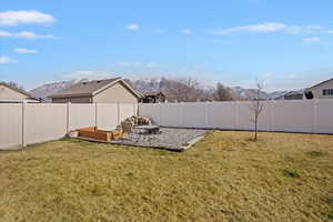 Fenced backyard with a mountain view and a fire pit