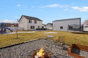 Fenced backyard with a patio, a fire pit, and an outbuilding