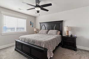 Bedroom with light colored carpet and a ceiling fan