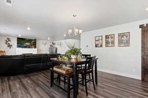 Dining area featuring dark wood finished floors and suspended lighting