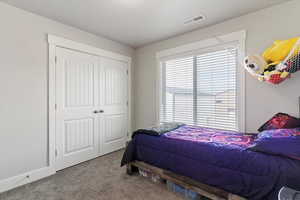 Carpeted bedroom featuring a closet