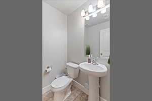 Half bath featuring baseboards and light tile patterned flooring