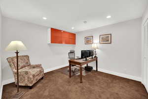 Office space featuring dark colored carpet and recessed lighting