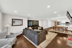 Living area with recessed lighting and dark wood-style flooring