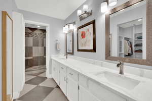 Master Bathroom featuring double vanity, dark floors, a shower stall, and a walk in closet