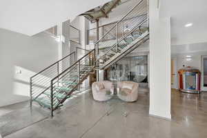 Stairway with a high ceiling and concrete flooring
