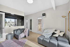 Living area with light wood-type flooring and beamed ceiling