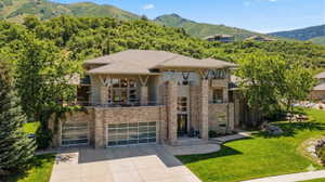 View of property featuring a mountain view, concrete driveway, and an attached garage