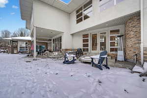 Snow covered patio with french doors and a patio