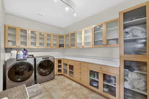 Laundry area with washer and dryer, light tile patterned flooring, and track lighting
