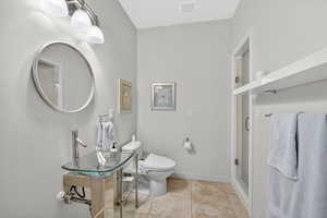 Bathroom featuring toilet and light tile patterned flooring