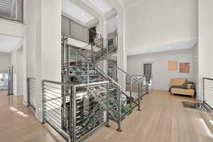 Stairs featuring a high ceiling and hardwood / wood-style floors