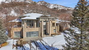 View of front facade with a mountain view, stone siding, and a balcony