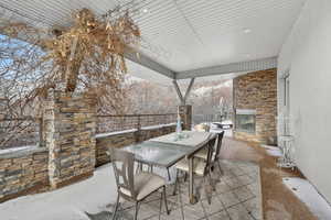 View of patio / terrace featuring outdoor dining area and a glass covered fireplace