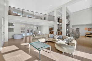 Living room featuring a high ceiling, french doors, wood finished floors, and recessed lighting