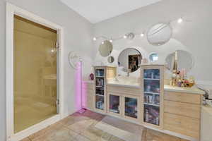 Bathroom with vanity, light tile patterned flooring, and a stall shower