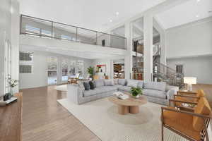 Living area with a high ceiling, hardwood / wood-style flooring, and recessed lighting