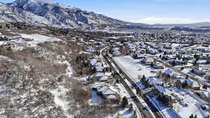 Snowy aerial view with a mountain view and a residential view
