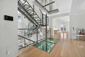 Hallway featuring light wood-style floors and a high ceiling