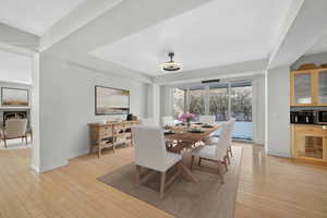 Dining room featuring light wood-style flooring and a lit fireplace