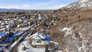 Snowy aerial view featuring a mountain view and a residential view