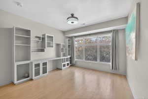 Unfurnished office featuring light wood finished floors and baseboards